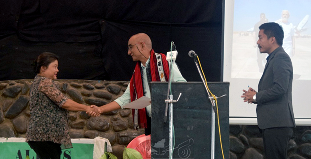 President of Ao Senden Chubawati Longchar presenting the Outstanding Achiever Award to Alila (Onchenna SHG) on the launching of ‘Hamara Sankalp, Vikshit Bharat Yatra’ held at Amphitheatre Ungma Village, Mokokchung.