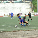 Players of Sechü Zubza FC (in blue) and Ward-19 (in black) battle for possession during their hard-fought encounter at IG Stadium, Kohima, in the 25th NSF Martyrs’ Memorial Trophy 2025. SZFC advanced to the quarterfinals after a tense penalty shootout, thanks to captain Neithovilie Chalieu’s heroic saves.